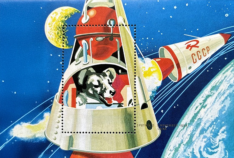 a postage stamp depicting Laika, the first dog in space. the rocket is red and gold. the background shows the earth from orbit.