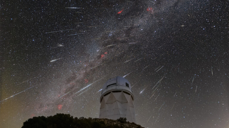meteors from the Geminid meteor shower streak across the sky above an observatory